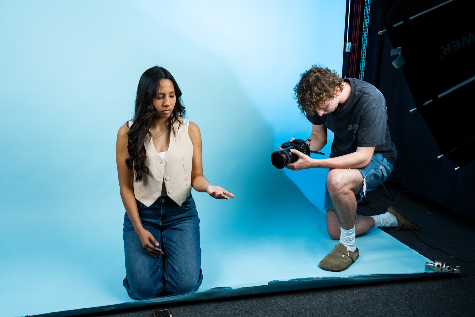 Filming a model on a sky-blue backdrop